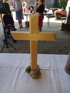 Ein Holzkreuz, das von Steinen gestützt wird.